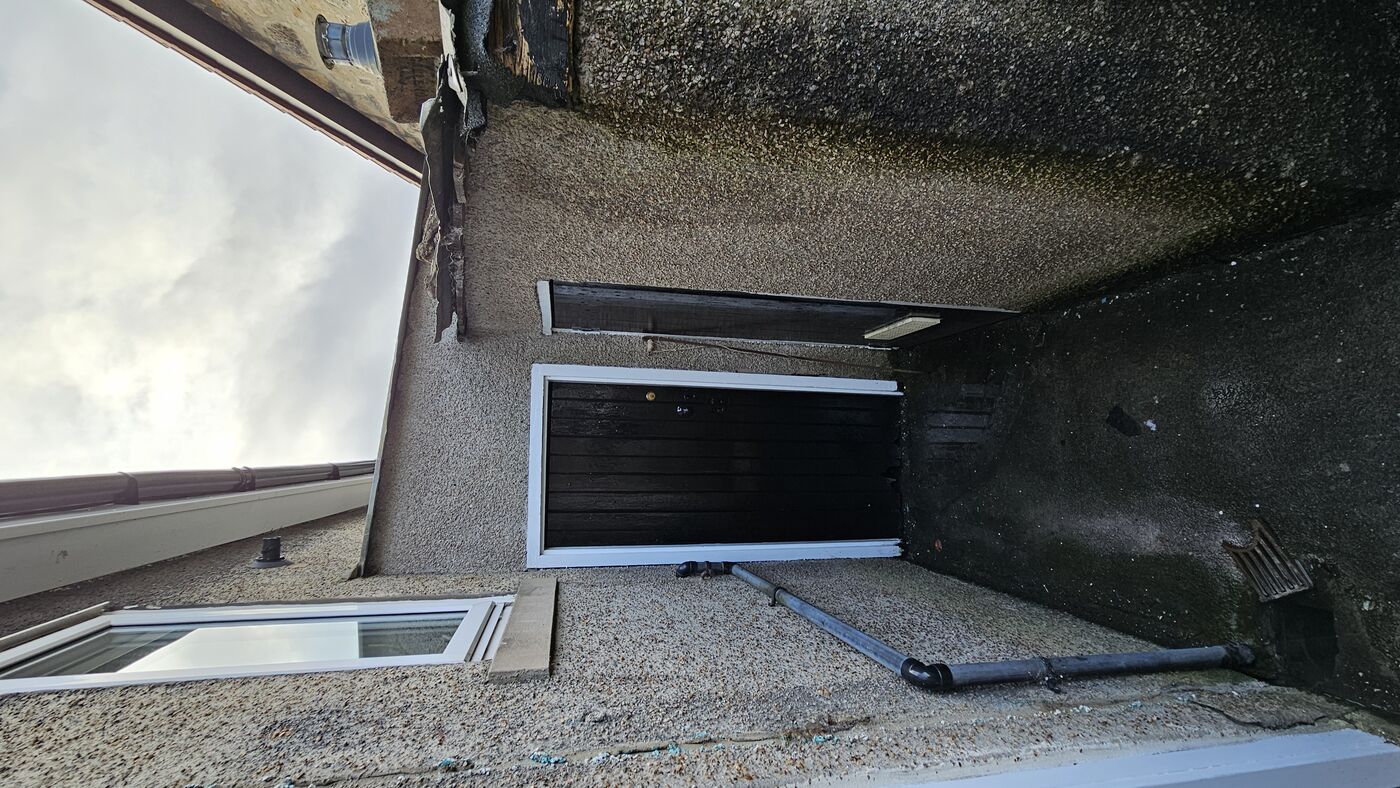 Back passage — crumbling render and damp