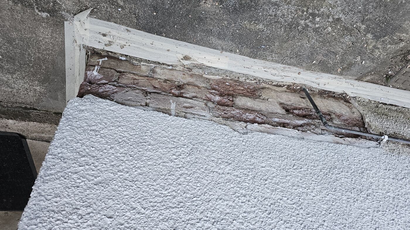Exposed brickwork — roughcast fully delaminated from wall